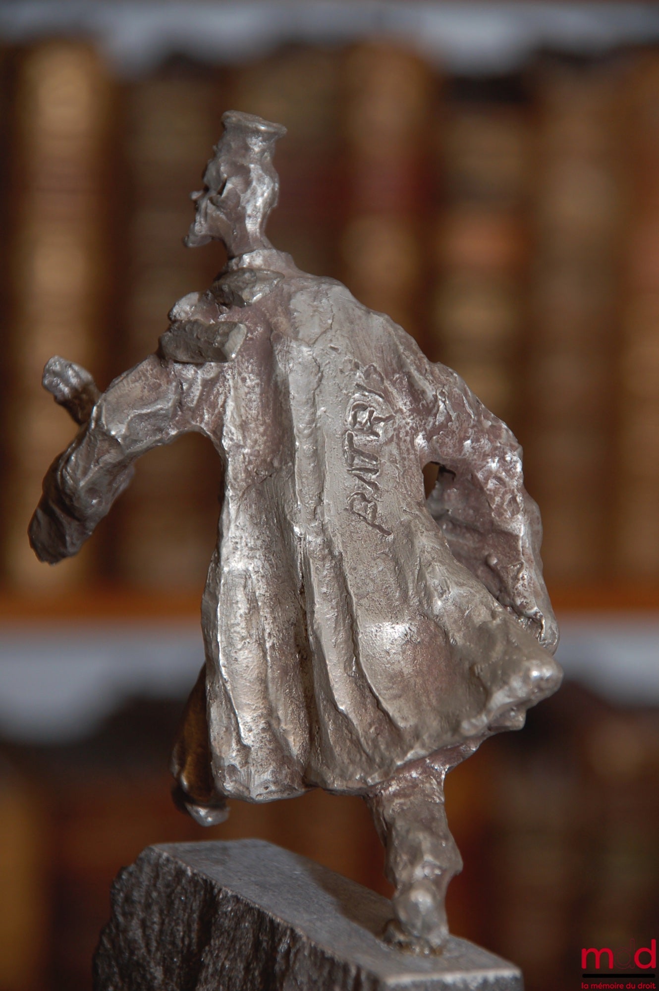 PATRIS (Ernest) – SCULPTURE AVOCAT EN ÉTAIN ; Belle et rare sculpture en étain représentant “un avocat afféré aux affaires” sur socle en pierre bleu d’une hauteur de 18 cm.